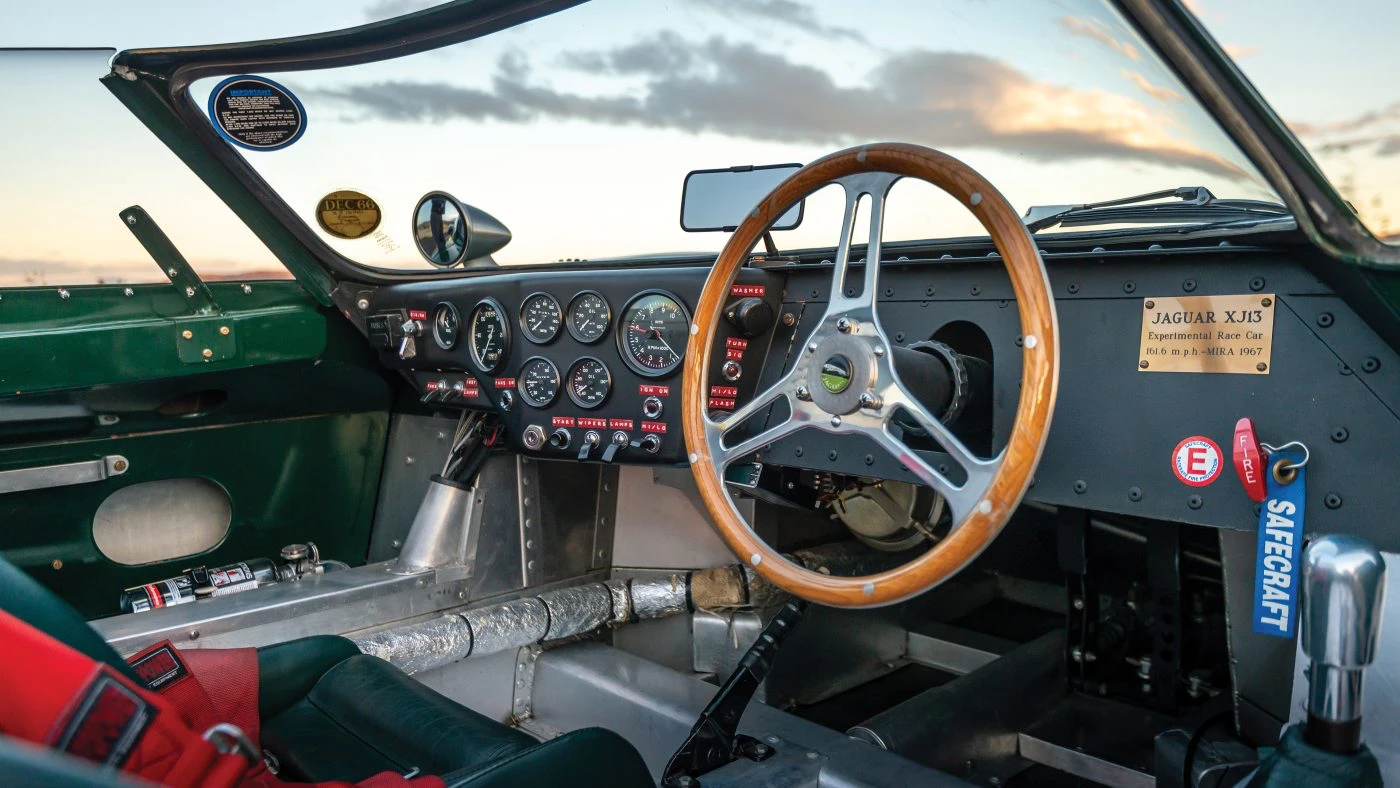 Cockpit interior of the Tempero XJ13 recreation showing the Smiths gauge cluster, wood-rim wheel, and switchgear