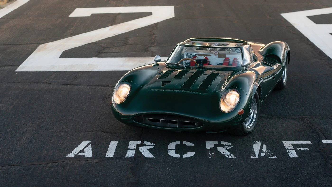Elevated front three-quarter view of the Tempero XJ13 recreation parked on an airfield apron marked AIRCRAFT