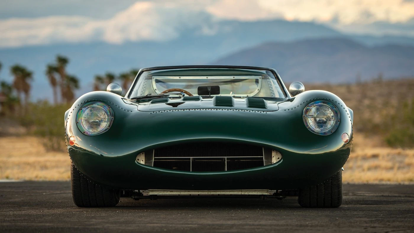 Head-on front view of the Tempero XJ13 recreation with headlamps lit, mountains in the background